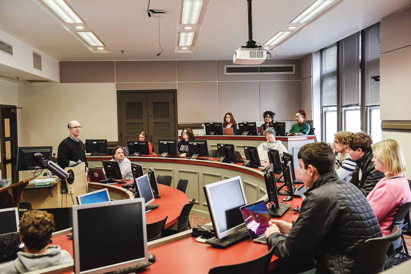 A college professor talks to a room full of students