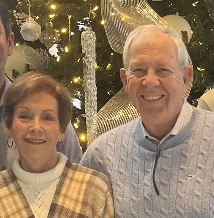 A couple in front of a holiday tree