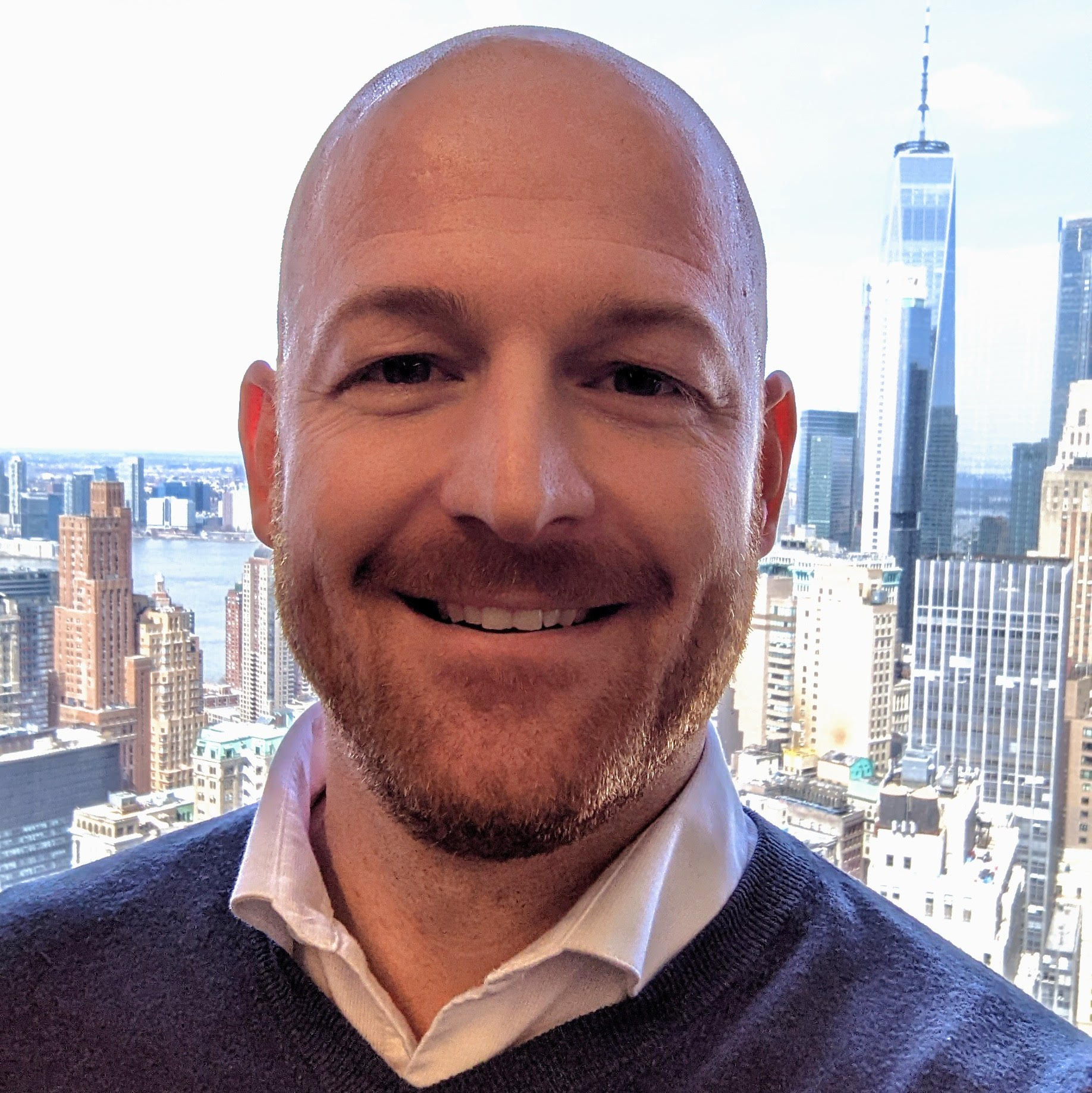 A photo of a man with a city skyline behind him