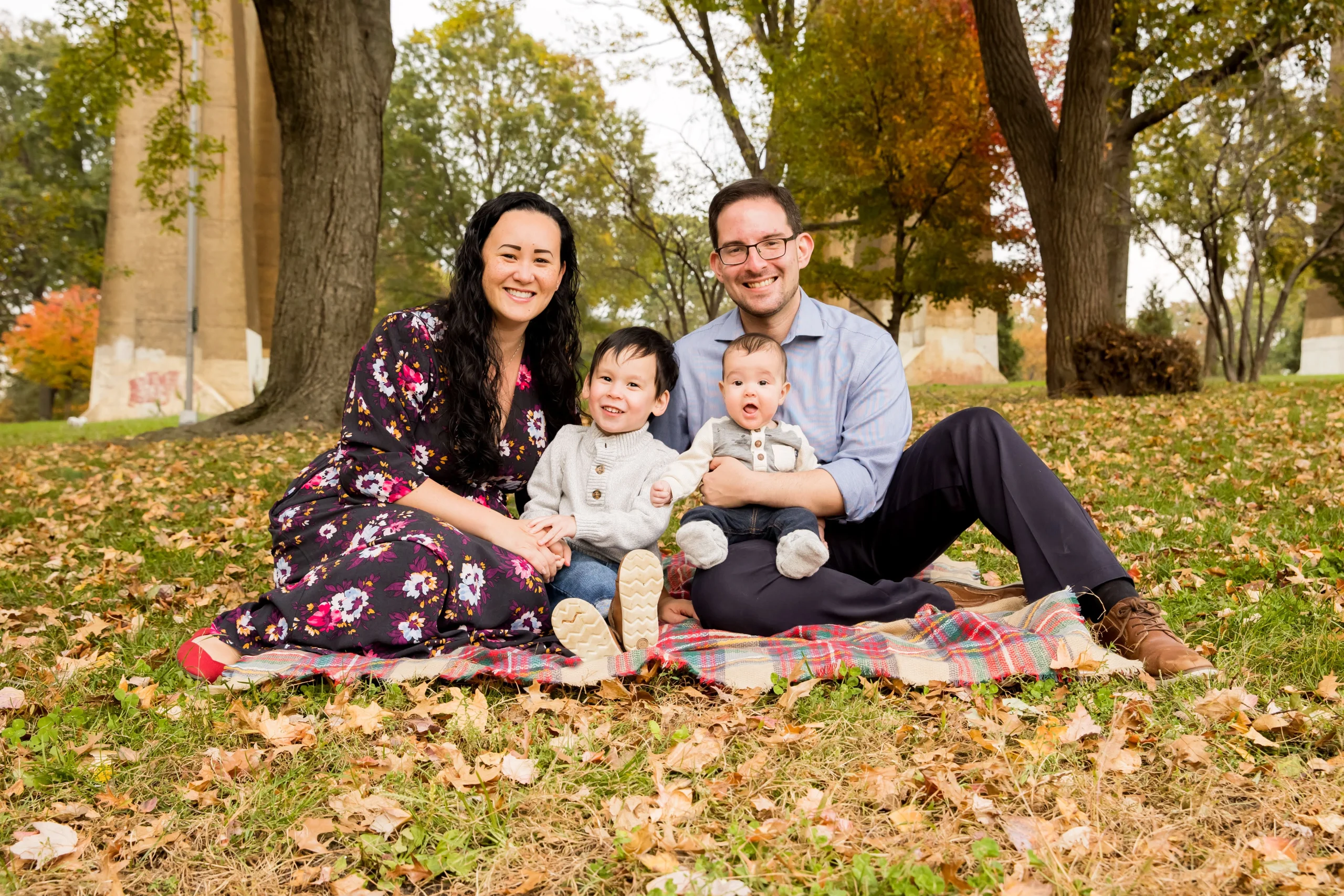 Two people pose with a small child and a baby for a family photo