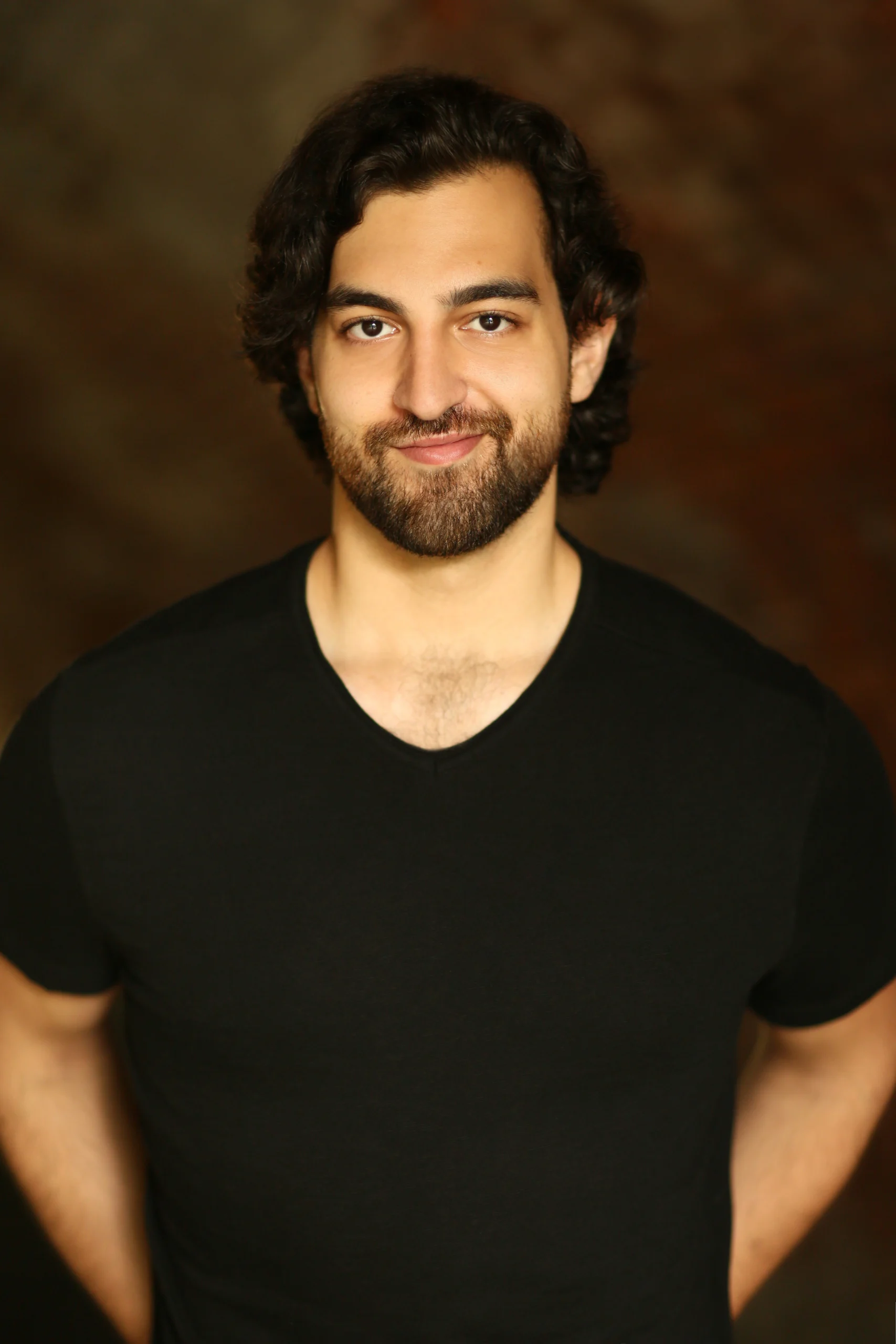 A headshot of an actor in a black T-shirt