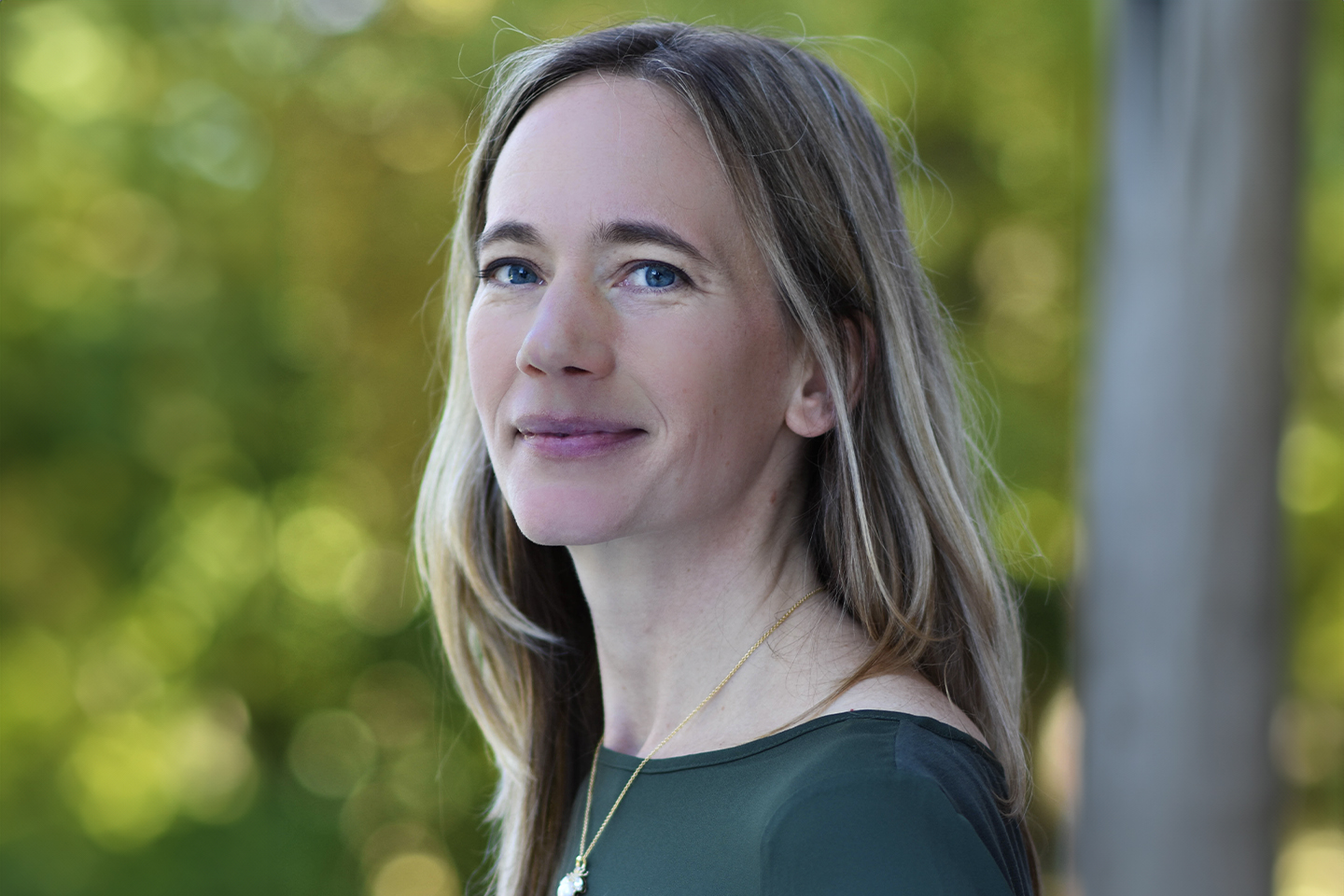 A headshot of a woman in a green shirt