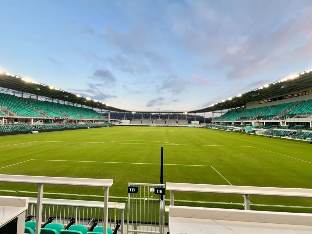 A brand new soccer field and stadium with teal seats