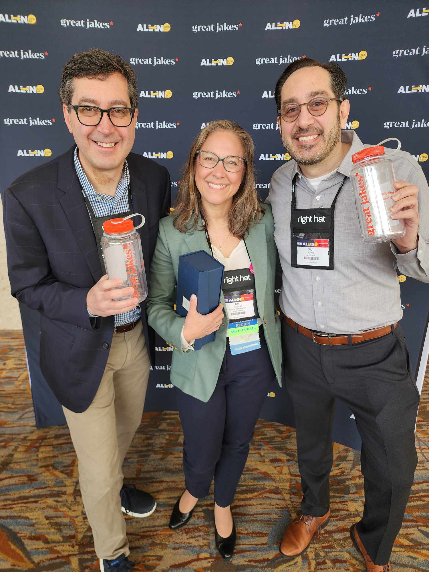 Three people smile for the camera at a professional conference