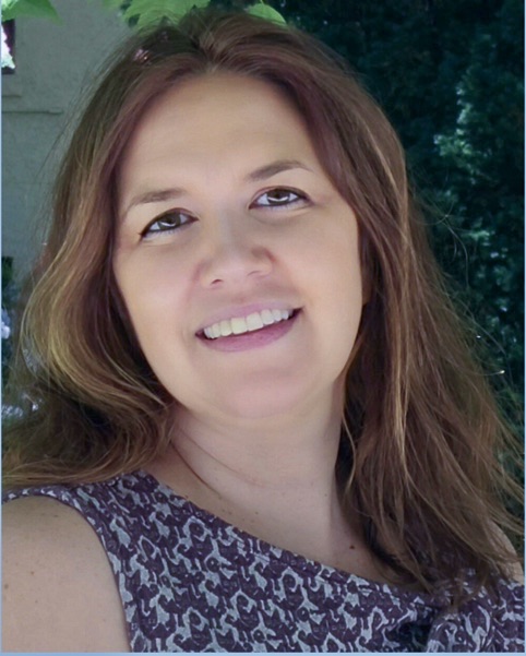 A headshot of a woman with long brown hair