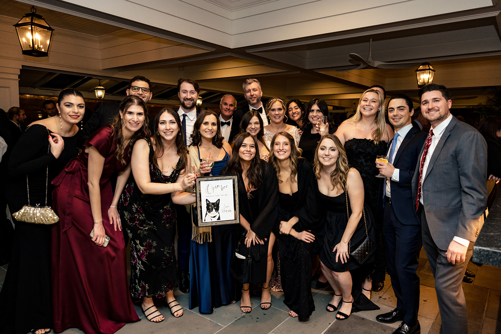 A large group of people dressed up at a wedding pose for a photo