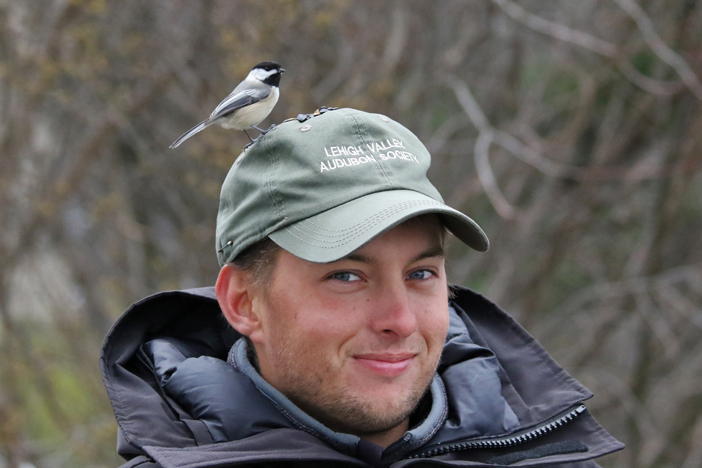 A young person wearing a hat that says Lehigh Valley Audubon Society with a bird perched on top