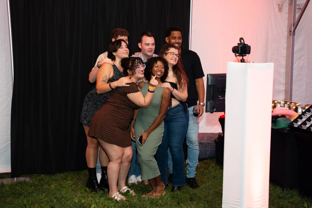 A group of young adults poses for a photo in a photobooth