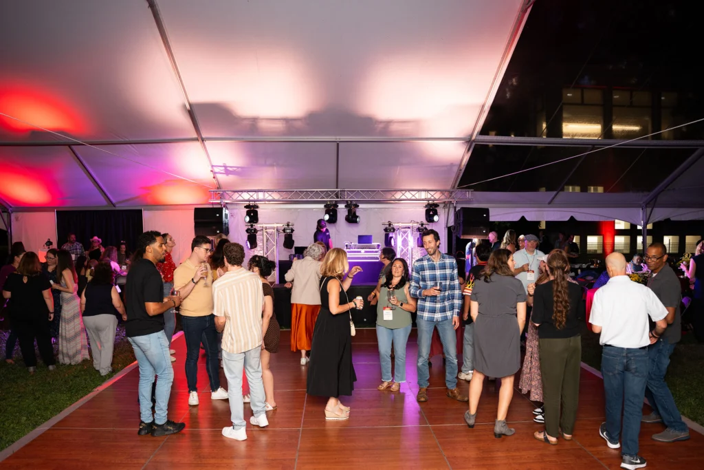 Adults on a dance floor under a tent