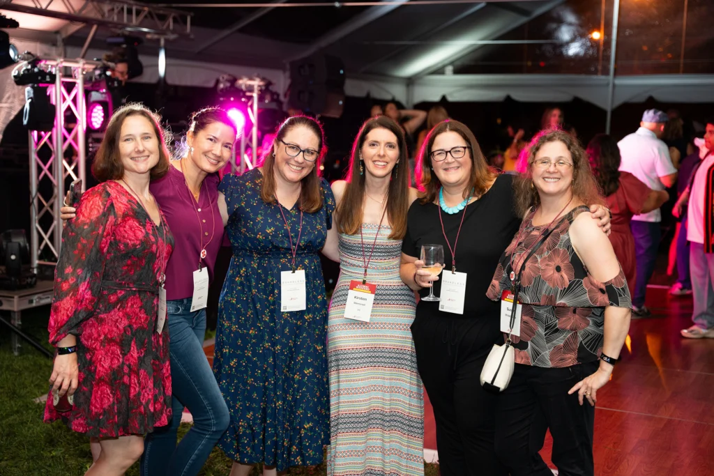 A group of women pose for a photo in front of a dance floor