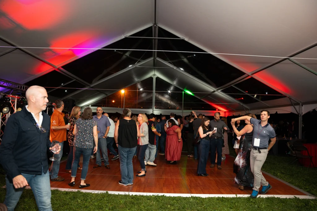 Adults on a dance floor under a tent