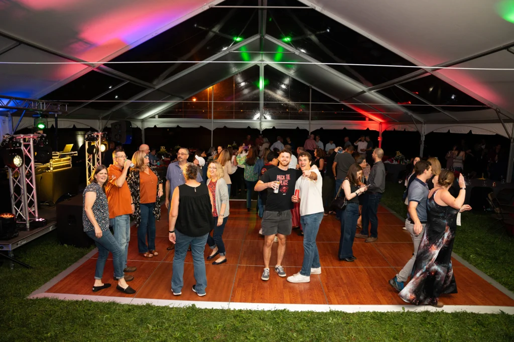 Adults on a dance floor under a tent