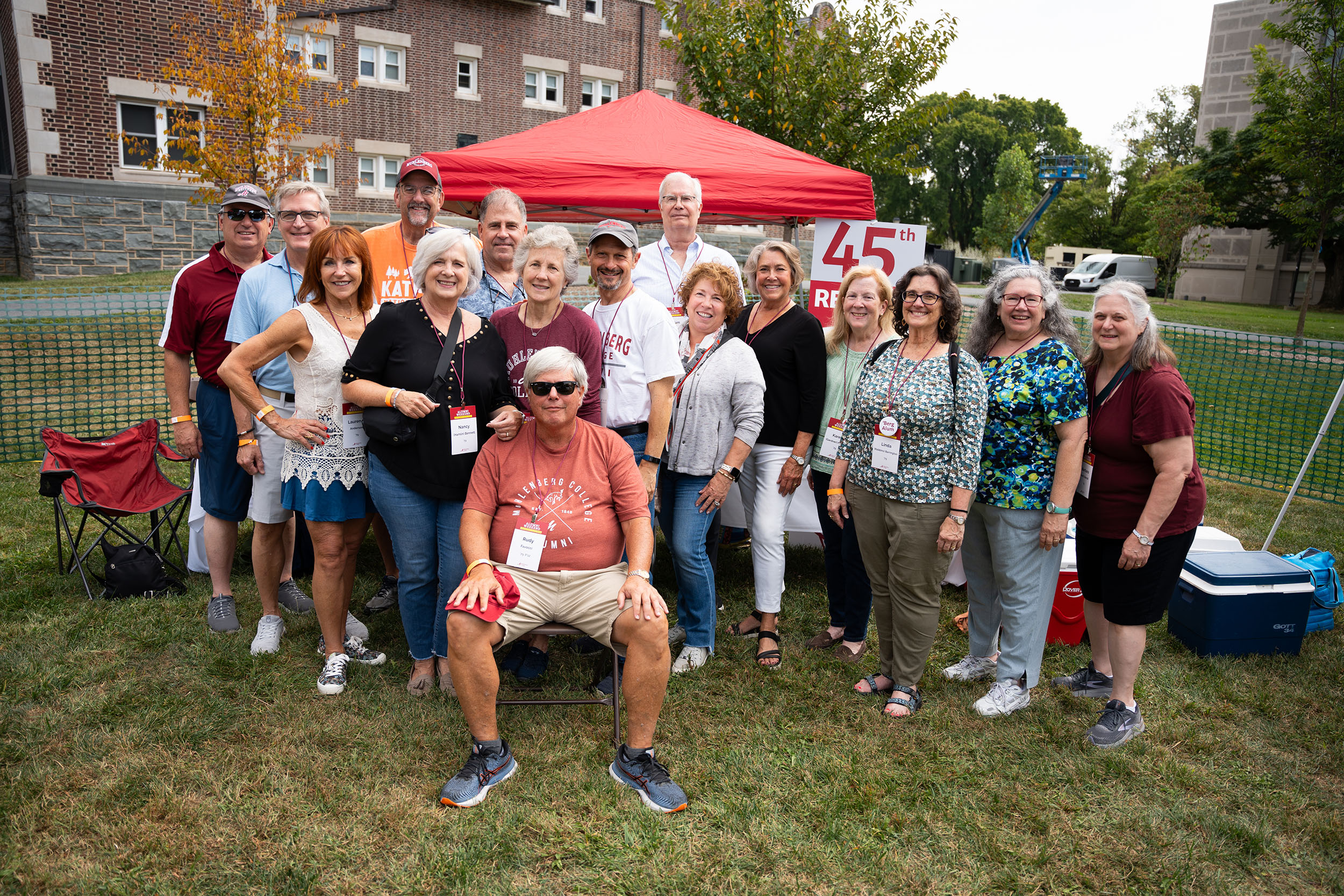 A large group of people at a tailgate in front of a tent that says 45th reunion