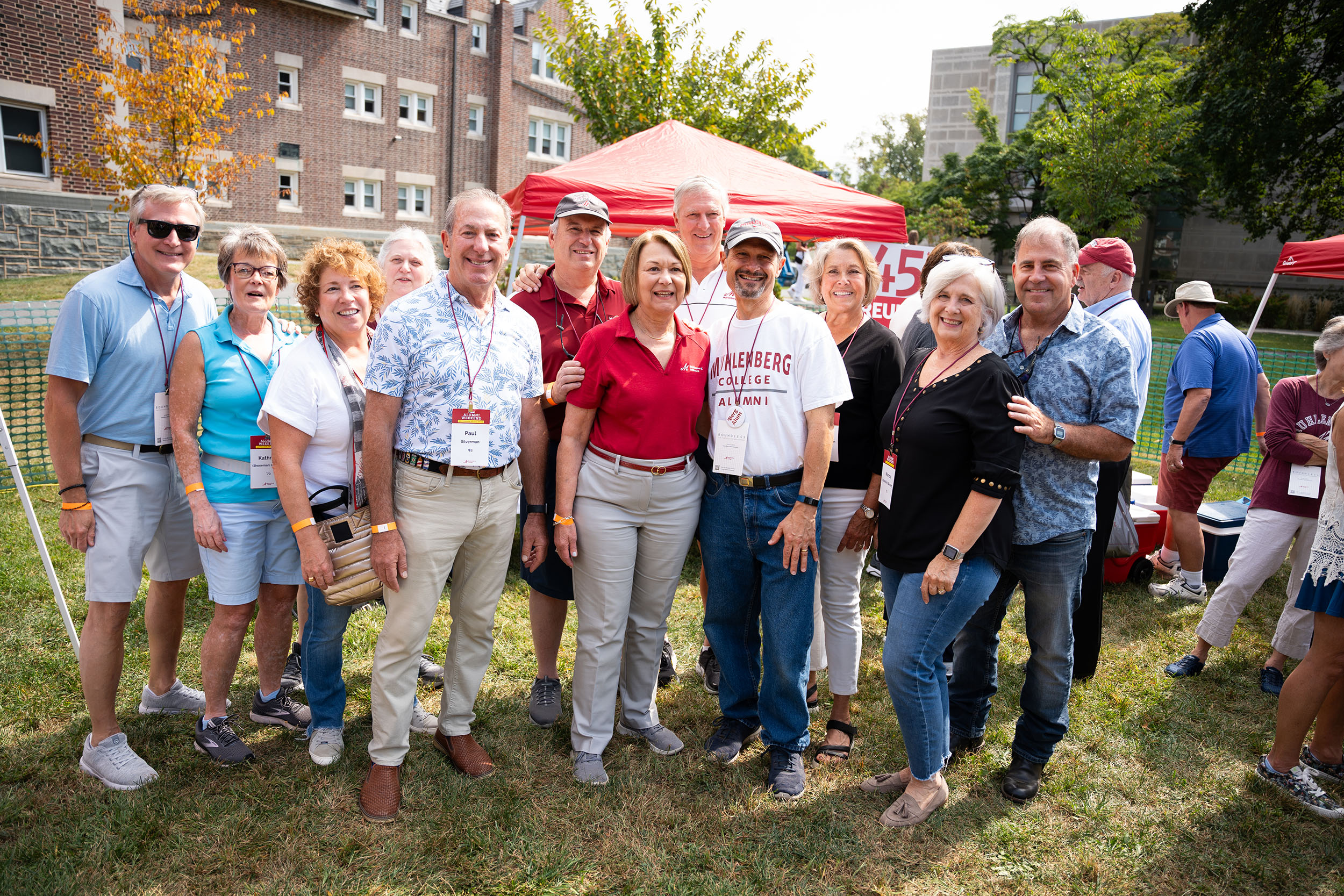 A group of friends with Muhlenberg's president in front of a sign that says 45th Reunion