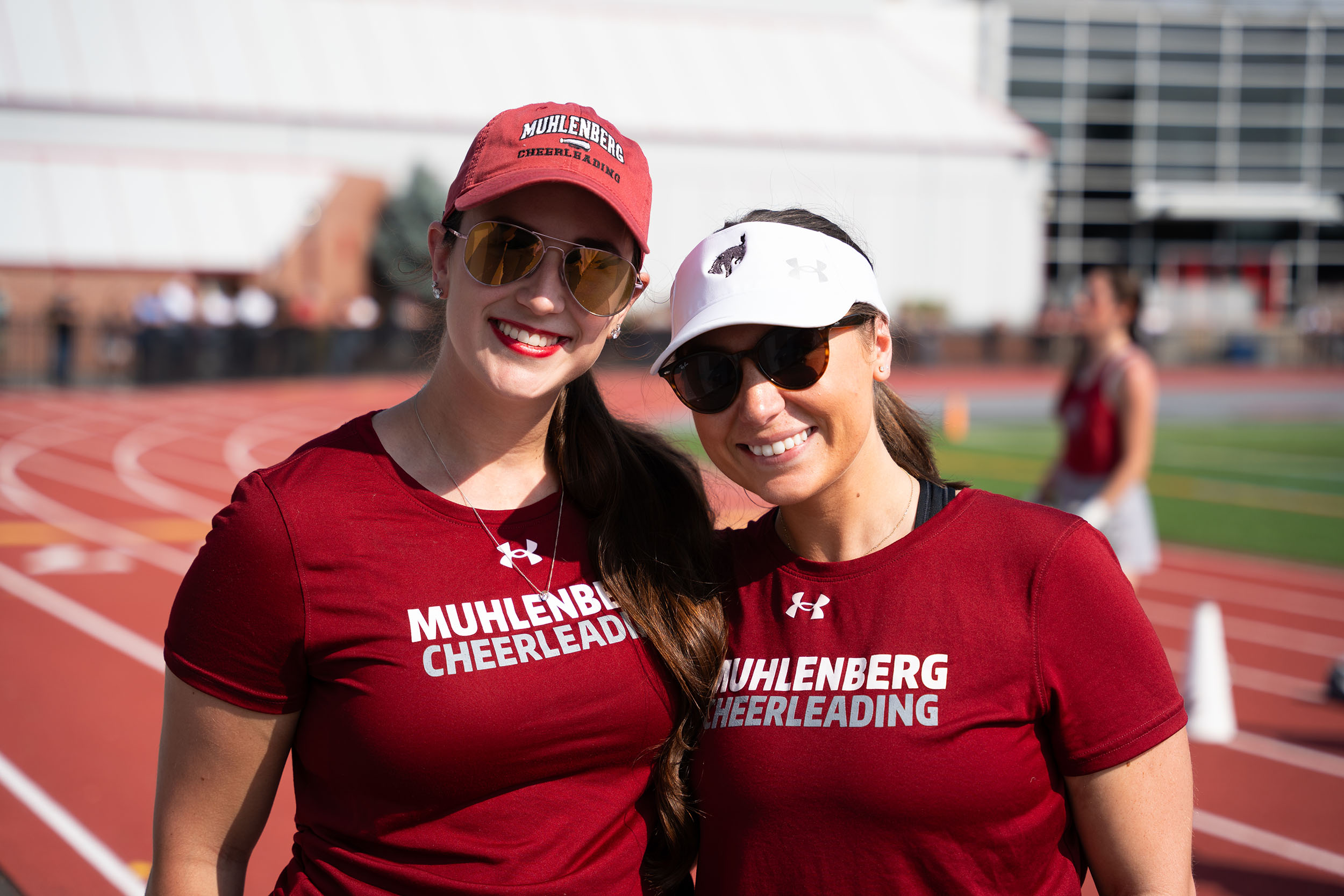 Two people wearing Muhlenberg Cheerleading shirts smile for the camera