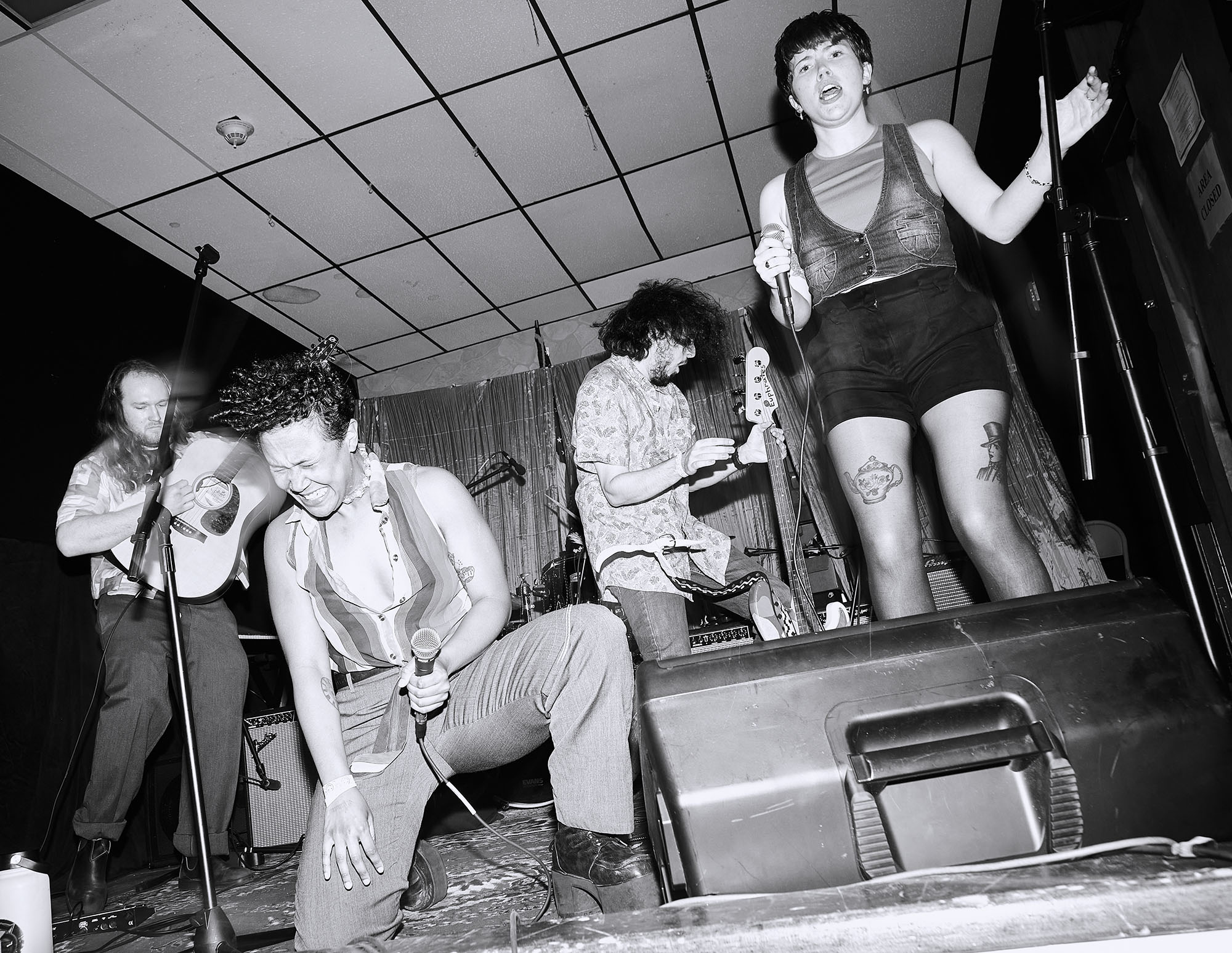 A black and white photo of a band performing on stage