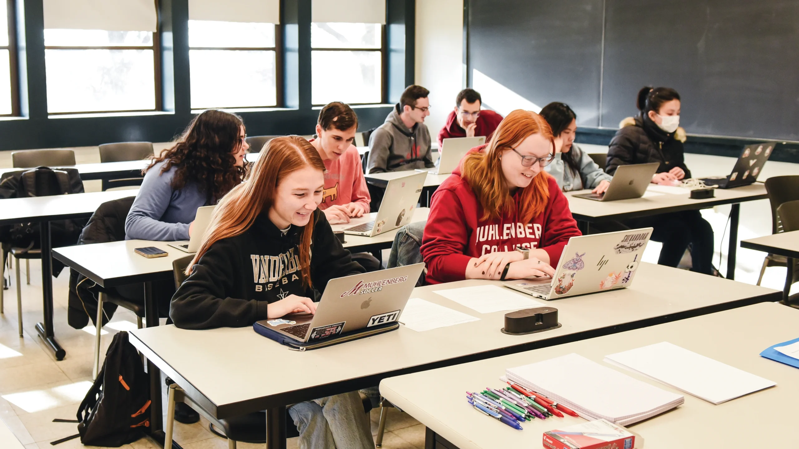 A class of students works in partners at tables