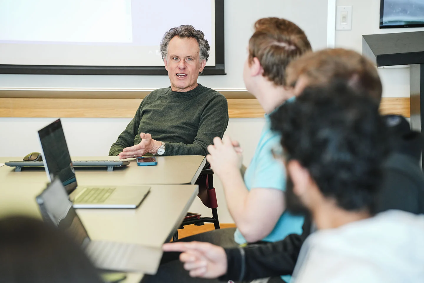 A college professor speaks with students during class