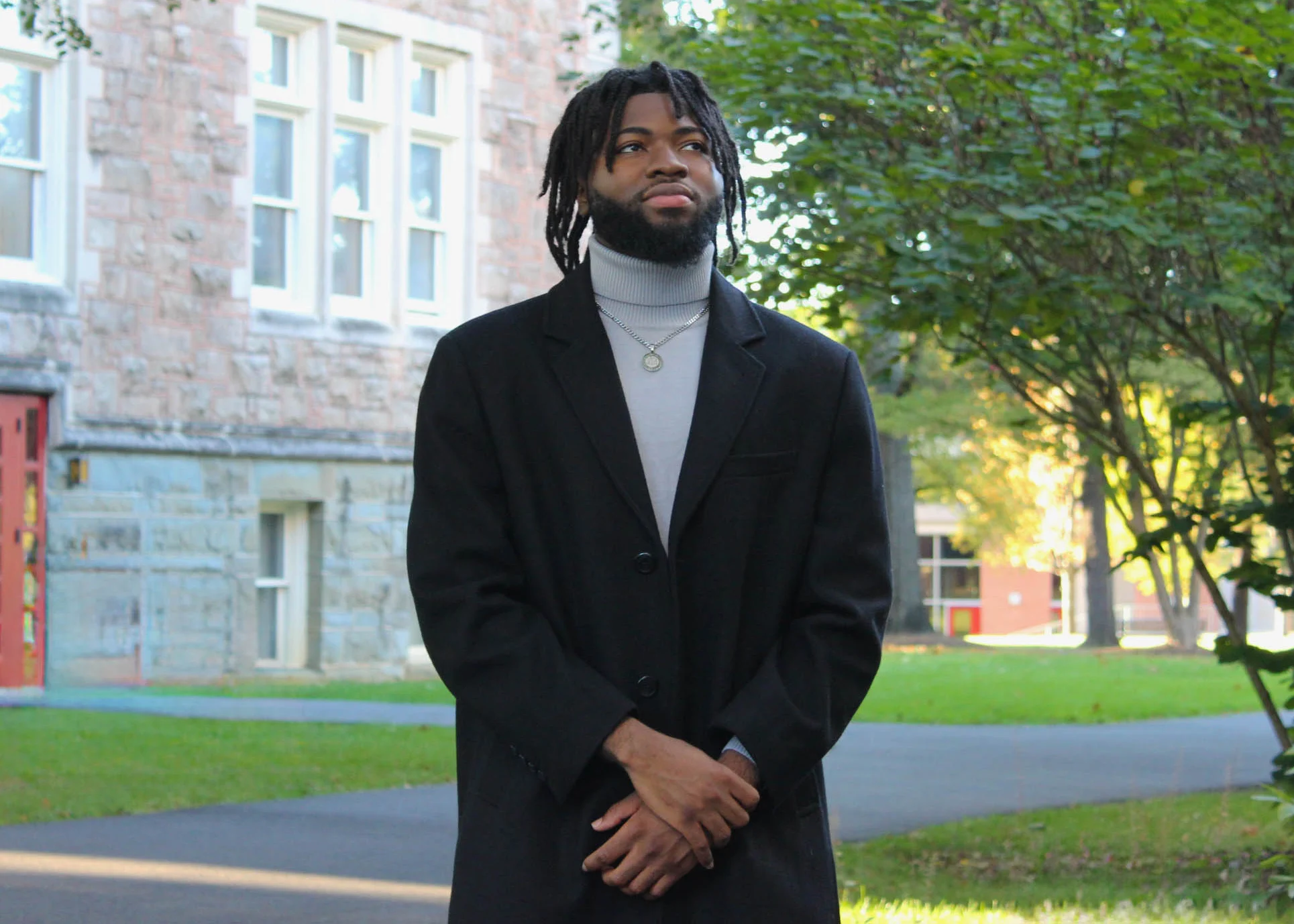 A photo of Maridie Naire looking up and off to the right while outside on Muhlenberg College's campus