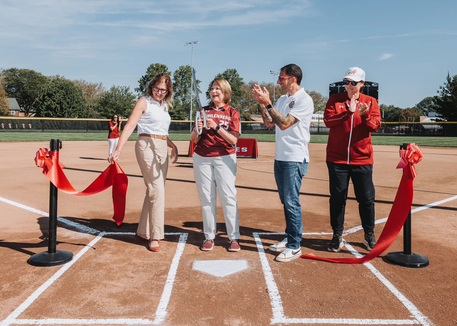 A photo of President Kathleen Harring cutting the opening ribbon at the new softball field
