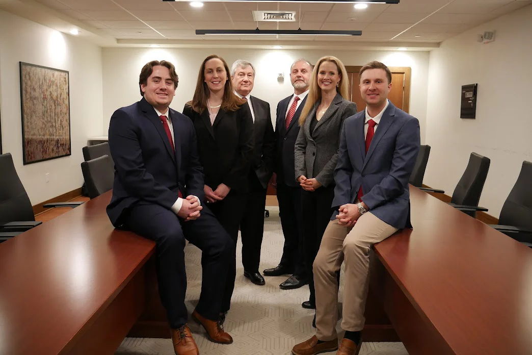 Six lawyers pose for a group photo in a boardroom
