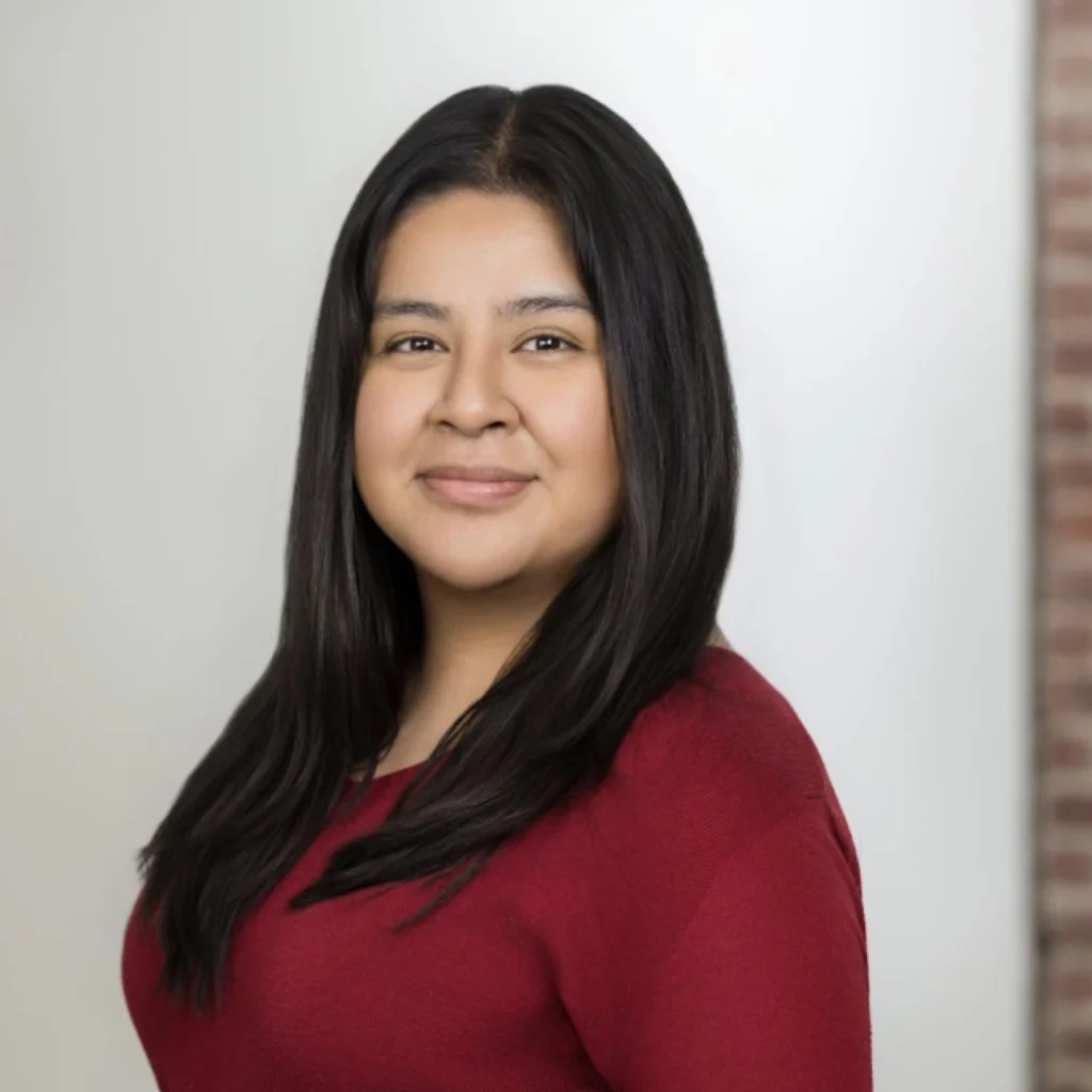 Headshot of woman with long dark hair in a red shirt
