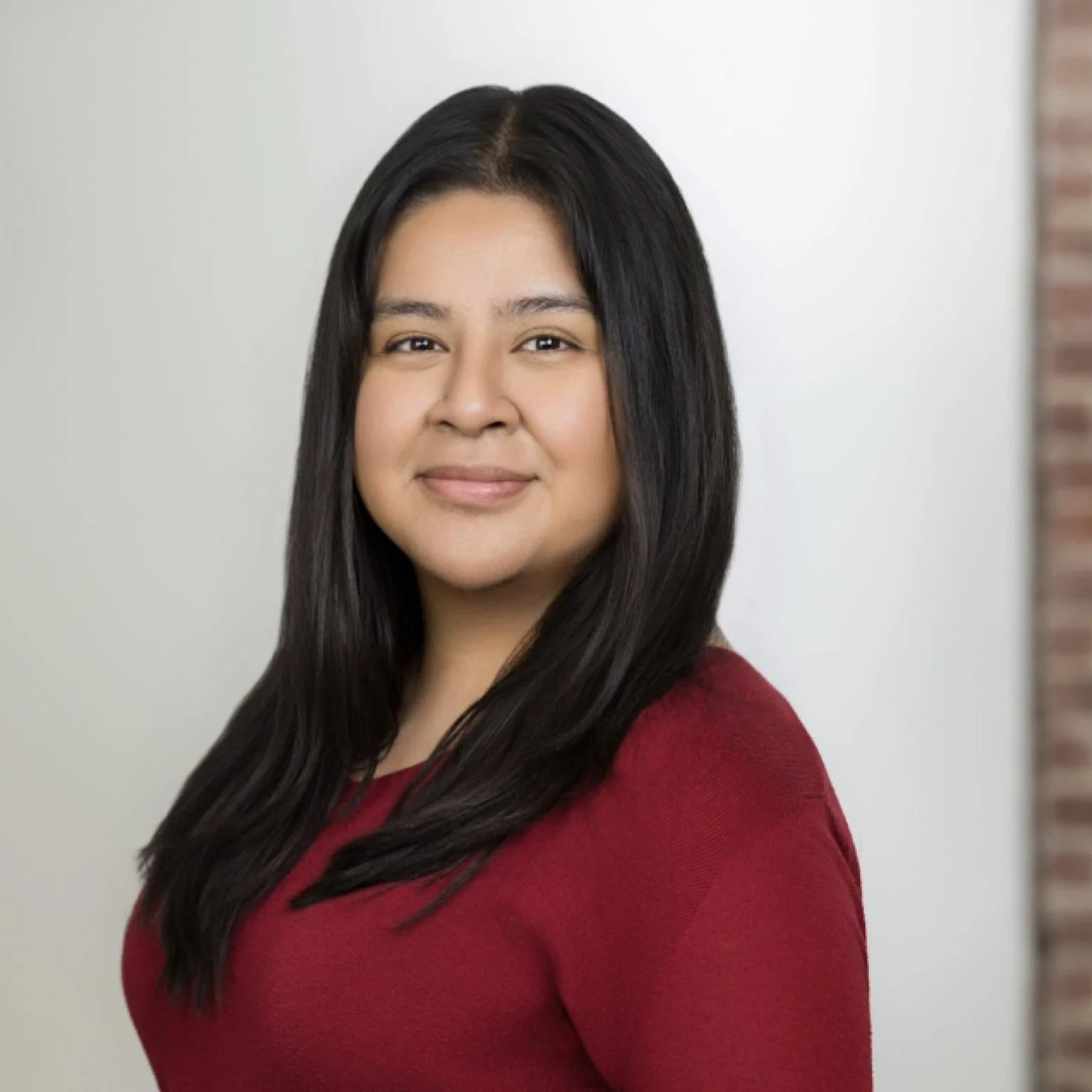 Headshot of woman with long dark hair in a red shirt