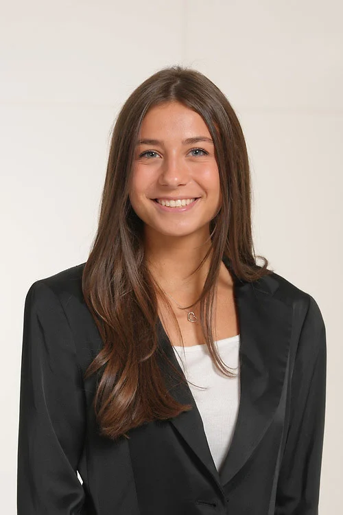 A young woman in a blazer and white shirt