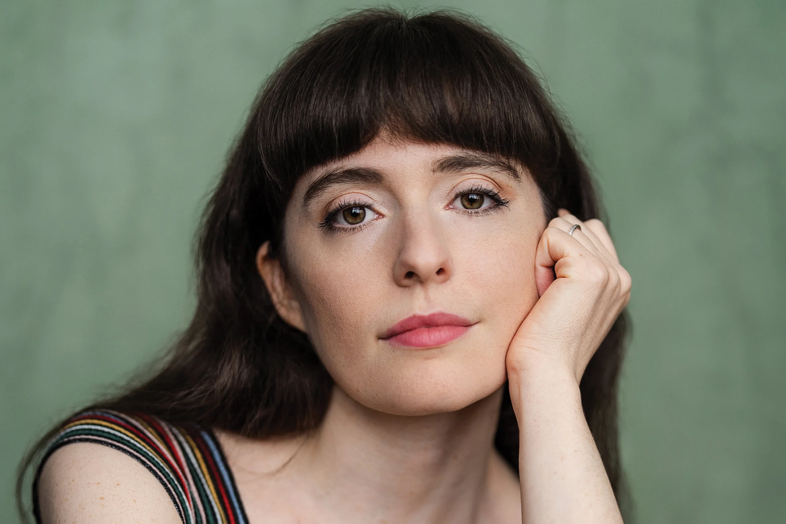 A headshot of a woman with dark hair and bangs